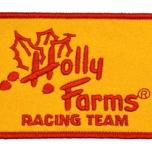 Könnte beinhalten: Roter und gelber gestickter Aufnäher mit dem Text "Holly Farms Racing Team" und einem stilisierten Stechpalmenblatt-Design.