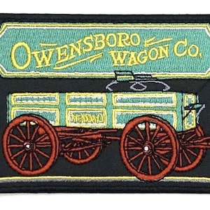 May include: An embroidered patch featuring a vintage wagon with the text "Owensboro Wagon Co." in yellow lettering on a teal sign above the wagon. The wagon is green and red with wooden wheels and a black background.