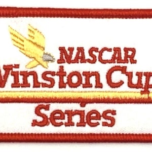 May include: A white rectangular patch with a red border. The patch features a yellow bird with outstretched wings, the text "NASCAR Winston Cup Series" in red, and a yellow stripe.