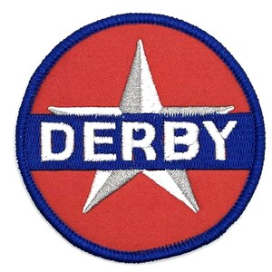 May include: An embroidered patch in red and blue with a white star and the word "DERBY" in white lettering.