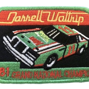 May include: Green and red embroidered patch with a black background featuring a green race car with the text "Darrell Waltrip" and "'81 Grand National Champion".