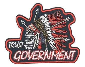May include: Black and red embroidered patch with a skull wearing a headdress and the text "TRUST THE GOVERNMENT".
