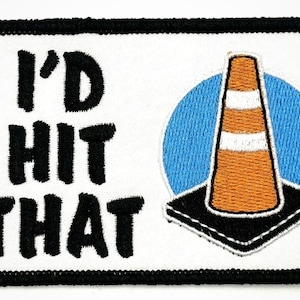 May include: White embroidered patch with black text that reads "I'd Hit That" and a cartoon image of an orange traffic cone with a white stripe on a blue circle.