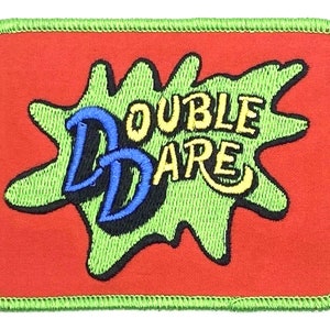 May include: Green and yellow embroidered patch with the words "Double Dare" on a red background.