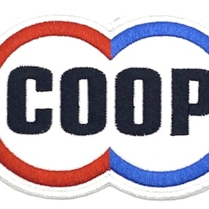 Op de afbeelding: Een witte geborduurde patch met een rood en blauw cirkelontwerp. Het woord "COOP" staat in zwarte letters binnen de cirkels.