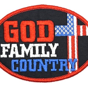 May include: An oval-shaped embroidered patch with red stitching around the edges. The patch is black with the words "GOD FAMILY COUNTRY" in red, white, and blue embroidery. A red, white, and blue American flag is embroidered in the shape of a cross on the right side of the patch.