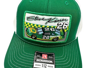 May include: Green and white trucker hat with a patch featuring a green race car with the number 26 and the name Steve Kinser. The patch also has the words "Quaker State" on it. The hat has an adjustable strap and the Richardson logo.
