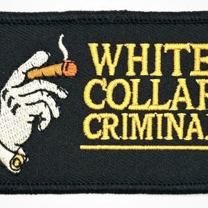Puede incluir: Parche bordado negro con las palabras "WHITE COLLAR CRIMINAL" en letras doradas. Una mano sosteniendo un cigarro encendido está bordada en el lado izquierdo. El parche tiene un borde negro.