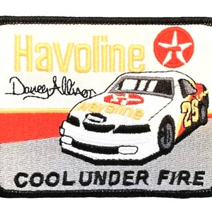 May include: A white Havoline race car with the number 25 on the side. The car is on a gray track with a red stripe. The text "Cool Under Fire" is below the car. The Havoline logo and a red star are above the car. The text "Darrel Allison" is above the car.