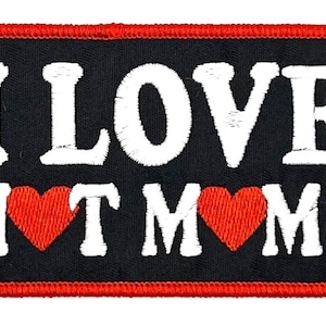 May include: Black embroidered patch with red stitching. The patch says "I LOVE HOT MOMS" with two red hearts.
