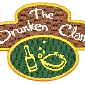 May include: Embroidered patch featuring the text "The Drunken Clam" in white script on a brown background. A green oval below displays a bottle and clam illustration in yellow.