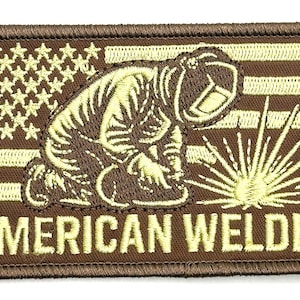 Può includere: Toppa ricamata marrone e beige. Raffigura un saldatore davanti a una bandiera americana, con la scritta "AMERICAN WELDER" sotto. La toppa ha un bordo marrone ed è adatta per l'applicazione su abbigliamento.