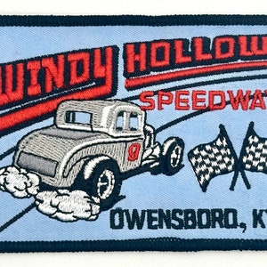 May include: A blue embroidered patch with the text "WINDY HOLLOW SPEEDWAY OWENSBORO, KY". A vintage race car with a checkered flag is in the center of the patch.