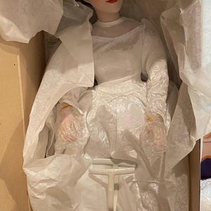 Porcelanowa lalka panna młoda „Her Traditional Garter” autorstwa Ashton-Drake Galleries