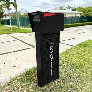May include: Black mailbox with a red flag and a white number plaque with the number 5911 on it.