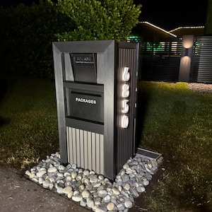 May include: A black mailbox with a gray and black striped panel and a white "PACKAGES" label. The mailbox has a white illuminated address number "6850" on the right side.