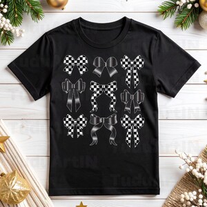 Może przedstawiać: Czarny t-shirt z wzorem dziewięciu kokard w r&oacute;żnych stylach. Niekt&oacute;re kokardy mają wz&oacute;r w czarno-białą szachownicę, inne są jednolicie czarne. Kokardy ułożone są w trzech rzędach po trzy.