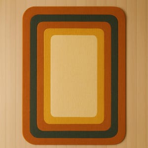 Könnte beinhalten: Rechteckiger Teppich mit abgerundeten Ecken, mit einem Retro-Farbschema. Der Teppich hat ein geschichtetes Design mit einer hellgelben Mitte, umgeben von Bändern in Gold, Dunkelgrün und Rostorange. Der Teppich liegt auf einem hellen Holzboden.