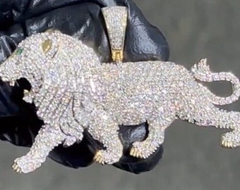 May include: A gold lion pendant covered in sparkling clear and white cubic zirconia stones. The pendant is detailed with a roaring lion face and a curled tail.
