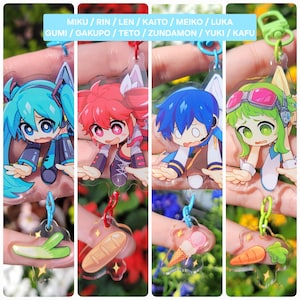 May include: A collection of anime-style acrylic keychains featuring various characters with vibrant hair colors and expressive faces. Each keychain has a unique charm at the bottom, including a leek, bread, ice cream cone, and carrot. The text at the top lists character names.