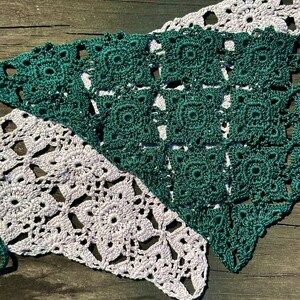 May include: Two crocheted triangular pieces of fabric, one in a light lavender color and the other in a dark green color. The fabric is made of a delicate, lacy pattern.