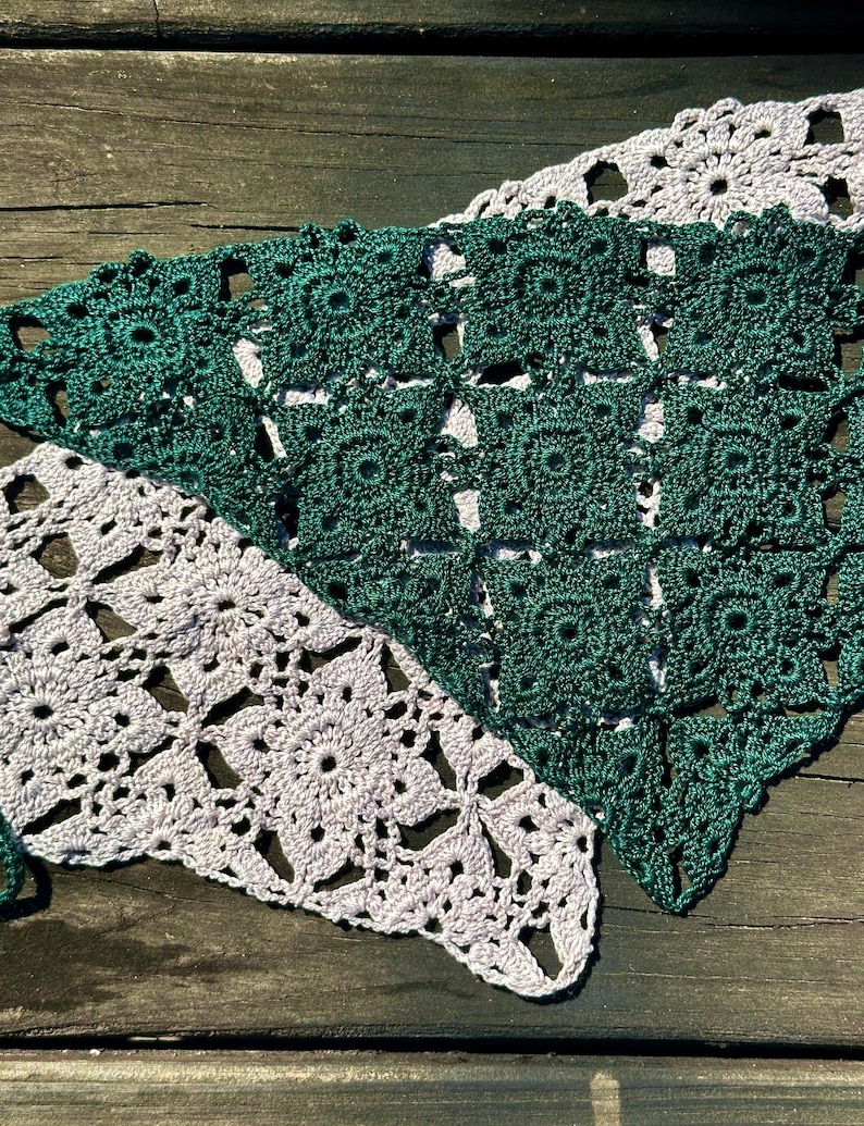 May include: Two crocheted triangular pieces of fabric, one in a light lavender color and the other in a dark green color. The fabric is made of a delicate, lacy pattern.