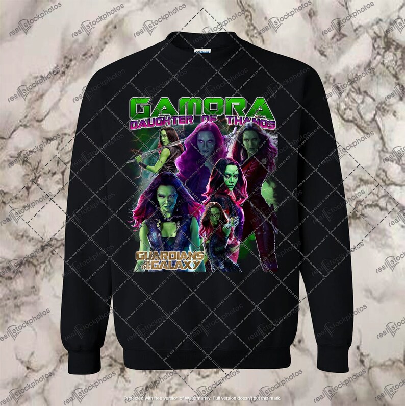May include: Black sweatshirt with a green, purple, and red graphic print of Gamora from Guardians of the Galaxy. The text "Gamora Daughter of Thanos" is printed in white on the shirt.