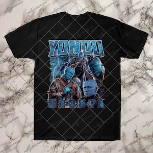 May include: A black t-shirt with a graphic print of Yondu Udonta from Guardians of the Galaxy. The graphic is in a blue and white color scheme with a lightning bolt design.