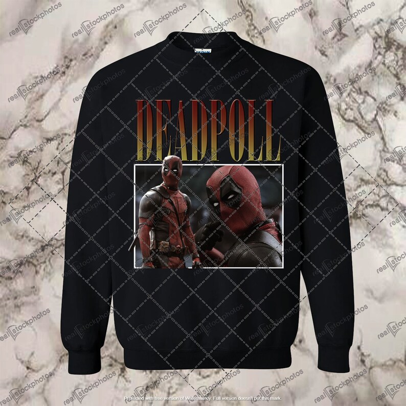 K&ouml;nnte beinhalten: Schwarzes Sweatshirt mit einem Grafikdruck von Deadpool in einem gelben und roten 'DEADPOOL'-Textfeld.