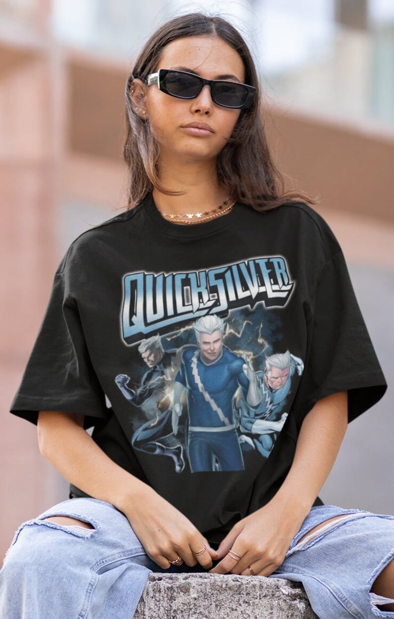 May include: Black t-shirt with a graphic print of Quicksilver from the Marvel comics. The graphic features Quicksilver in a blue and silver costume with lightning bolts.