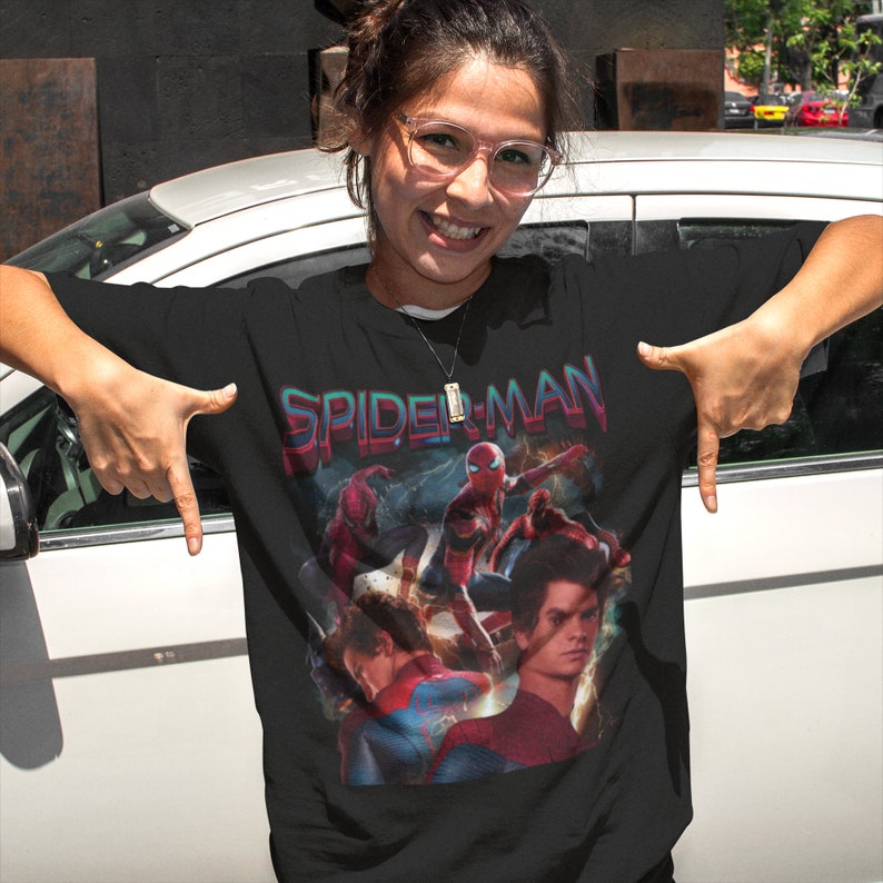May include: Black t-shirt with a graphic print of Spider-Man characters from the movie Spider-Man: No Way Home. The text "SPIDER-MAN" is printed in a retro style font above the characters.