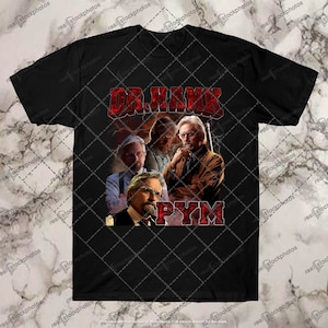 Puede incluir: Camiseta negra con un gráfico rojo de un collage de cuatro caras de hombres. El texto "Dr. Hank Pym" está en letras rojas.