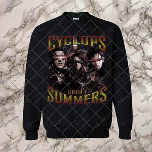 May include: Black sweatshirt with a graphic print of Cyclops from the X-Men comics. The graphic features a collage of different versions of Cyclops, with the text "Cyclops" and "Scott Summers" in a red and yellow font.