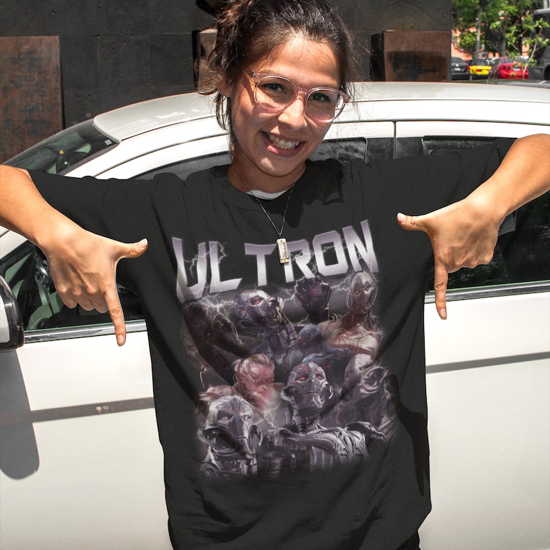 May include: Black t-shirt with a graphic print of the Marvel character Ultron. The graphic features Ultron and his robotic army in a vintage style.