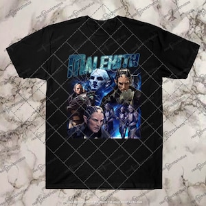 May include: Black t-shirt with a graphic print of a group of characters from the movie "Maleficent". The characters are in a blue and purple color scheme with a lightning bolt effect. The text "Maleficent" is printed in blue and white letters.