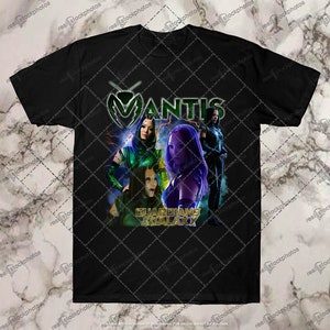 Könnte beinhalten: Schwarzes T-Shirt mit einem Grafikdruck eines Charakters aus dem Film Guardians of the Galaxy. Der Charakter ist Mantis, und der Text "MANTIS" ist in Grün und Gelb gedruckt. Der Text "GUARDIANS OF THE GALAXY" ist in Gold gedruckt.