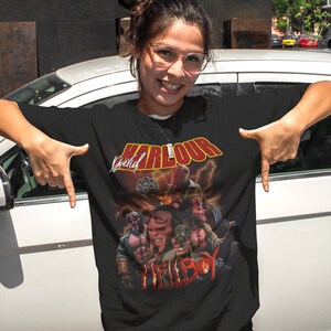 May include: Black t-shirt with a graphic print of a comic book character, Hellboy, with the text "Karlour Special" above him.