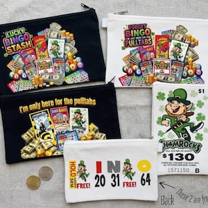 Può includere: Cinque astucci rettangolari con cerniera a tema bingo e biglietti a strappo. I disegni includono folletti, mazzette di banconote, cartelle del bingo e testi come Lucky Bingo Stash, Forget Bingo I'm Just Here For The Pulltabs e Shamrocks $130.