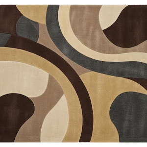 A high-angle shot of a rectangular hand-tufted wool area rug featuring a modern abstract pattern in brown, beige, tan, and grey. The rug is placed on a light oak wood floor in a bright living room next to a cream sofa, potted plants, and a wooden coffee table.
