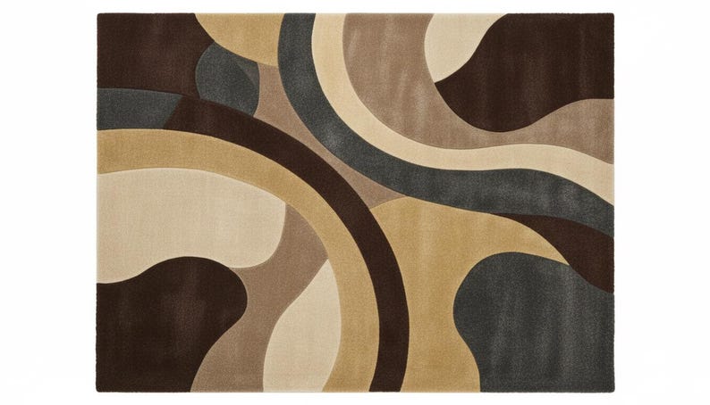 A high-angle shot of a rectangular hand-tufted wool area rug featuring a modern abstract pattern in brown, beige, tan, and grey. The rug is placed on a light oak wood floor in a bright living room next to a cream sofa, potted plants, and a wooden coffee table.