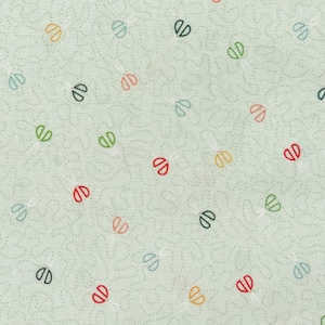 Może przedstawiać: Jasnozielona tkanina z powtarzającym się wzorem kolorowych, stylizowanych nożyczek. Nożyczki są w różnych kolorach, w tym czerwonym, zielonym, żółtym i niebieskim, rozrzucone po powierzchni.