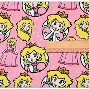 Könnte beinhalten: Rosafarbener Stoff mit einem sich wiederholenden Muster einer Comic-Prinzessin, die eine Krone und ein rosa Kleid trägt. Der Hintergrund ist rosa mit weißen Sternen.