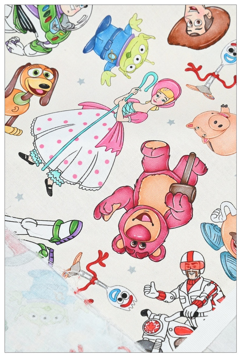 May include: A white fabric with a colorful pattern of Toy Story characters. The characters include Woody, Buzz Lightyear, Jessie, Mr. and Mrs. Potato Head, Rex, and Hamm. The fabric is perfect for quilting, crafts, and other projects.