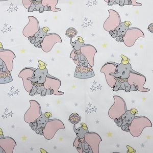 Könnte beinhalten: Ein sich wiederholendes Muster mit der Zeichentrickfigur Dumbo, dem Elefanten. Dumbo wird in verschiedenen Posen dargestellt, mit rosa Ohren und einem gelben Hut, vor einem weißen Hintergrund mit gelben und grauen Sternen.