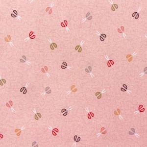 Może przedstawiać: Różowy materiał z powtarzającym się wzorem małych, kolorowych nożyczek. Nożyczki są w różnych kolorach, w tym czerwonym, niebieskim, zielonym i brązowym.