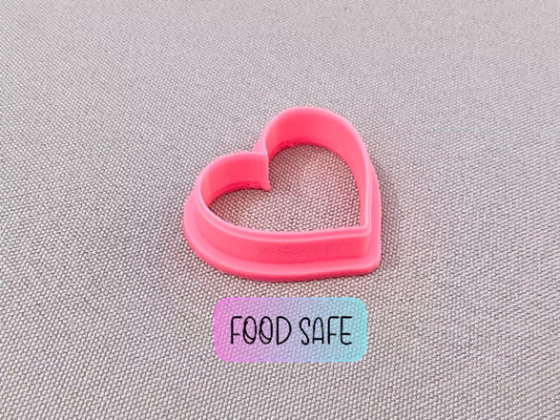 May include: Pink plastic heart-shaped cookie cutter. The cutter is food safe.