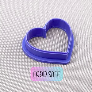 May include: Purple plastic heart-shaped cookie cutter.  Food safe.