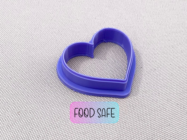 May include: Purple plastic heart-shaped cookie cutter.  Food safe.