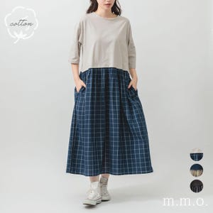 Può includere: Abito a due pezzi beige e blu navy a quadri. La parte superiore è beige con maniche a tre quarti. La gonna midi è a quadri blu navy e bianca. L'abito ha tasche e si indossa con scarpe da ginnastica bianche.