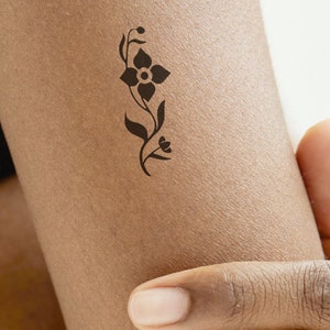 A FLOWER delicate and feminine temporary tattoo in black.